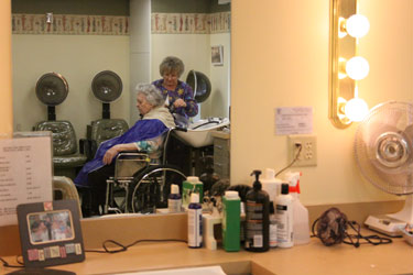 An elderly woman getting her hair cut